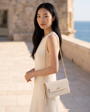 La Pochette Blanc cassé portée, chaîne dorée
