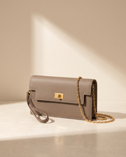 La Pochette en cuir de vachette 2ᵉ fleur, coloris Gris éléphant, fermoir tournant doré et chaîne
