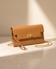 La Pochette en cuir de vachette 2ᵉ fleur, coloris Brun doré, fermoir tournant doré et chaîne