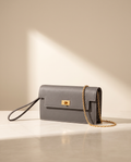 La Pochette en cuir de vachette 2ᵉ fleur, coloris Gris étain, fermoir tournant doré et chaîne