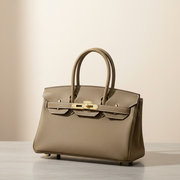 Le Firkin en cuir de vachette pleine fleur, coloris Éléphant taupe, boucle dorée