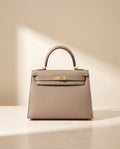 La Duchesse, sac à rabat en cuir de vachette, coloris gris éléphant, fermoir à tourniquet doré, vue de face