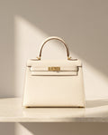 La Duchesse, sac à rabat en cuir de vachette, coloris blanc crème, fermoir à tourniquet doré, vue de face