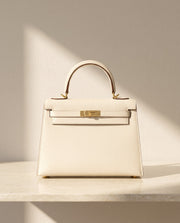 La Duchesse, sac à rabat en cuir de vachette, coloris blanc crème, fermoir à tourniquet doré, vue de face