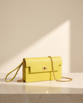 La Pochette en cuir de vachette 2ᵉ fleur, coloris Jaune, fermoir tournant doré et chaîne